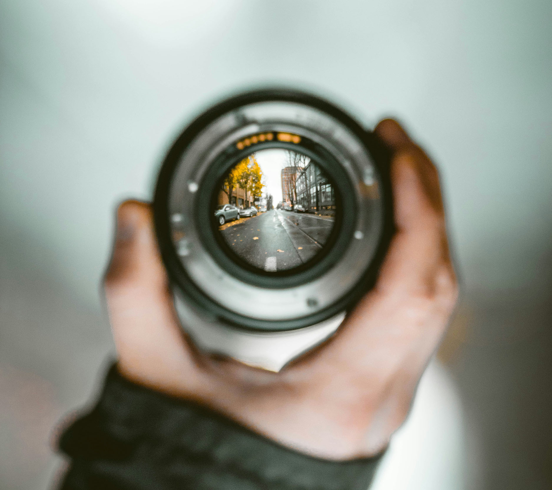 hand holding a camera lens showing a view of a street that's in focus, Sheaff Brock investment advisors blog, retail consumers