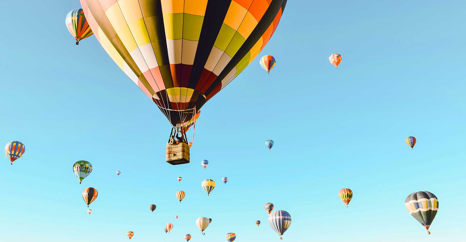 multiple hot air balloons in the sky, some large and up close and many of them smaller and farther away, Sheaff Brock investment advisors blog, retail consumers