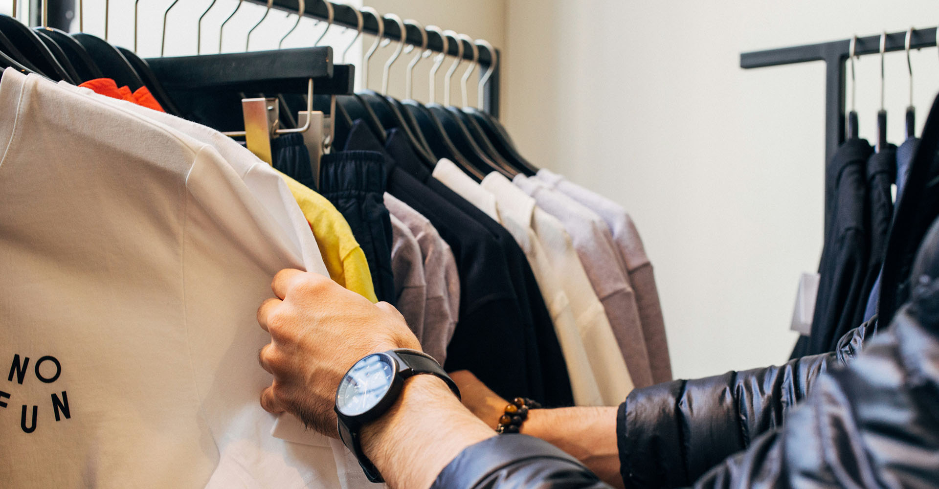 a pair of man's hands looking through shirts on a sales rack, Sheaff Brock investment advisors blog, retail consumers