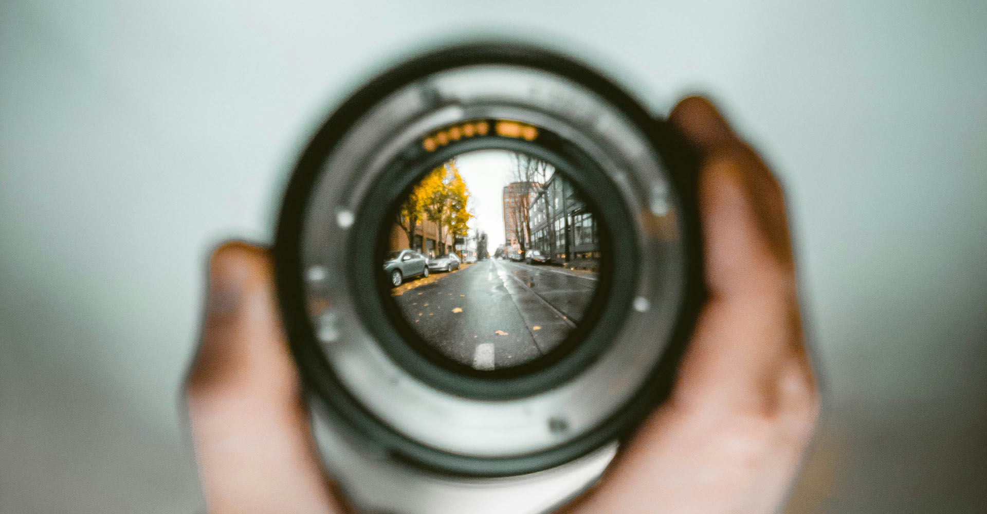 close-up of a camera lens that shows a street with cars in focus, Sheaff Brock investment advisors blog, retail consumers