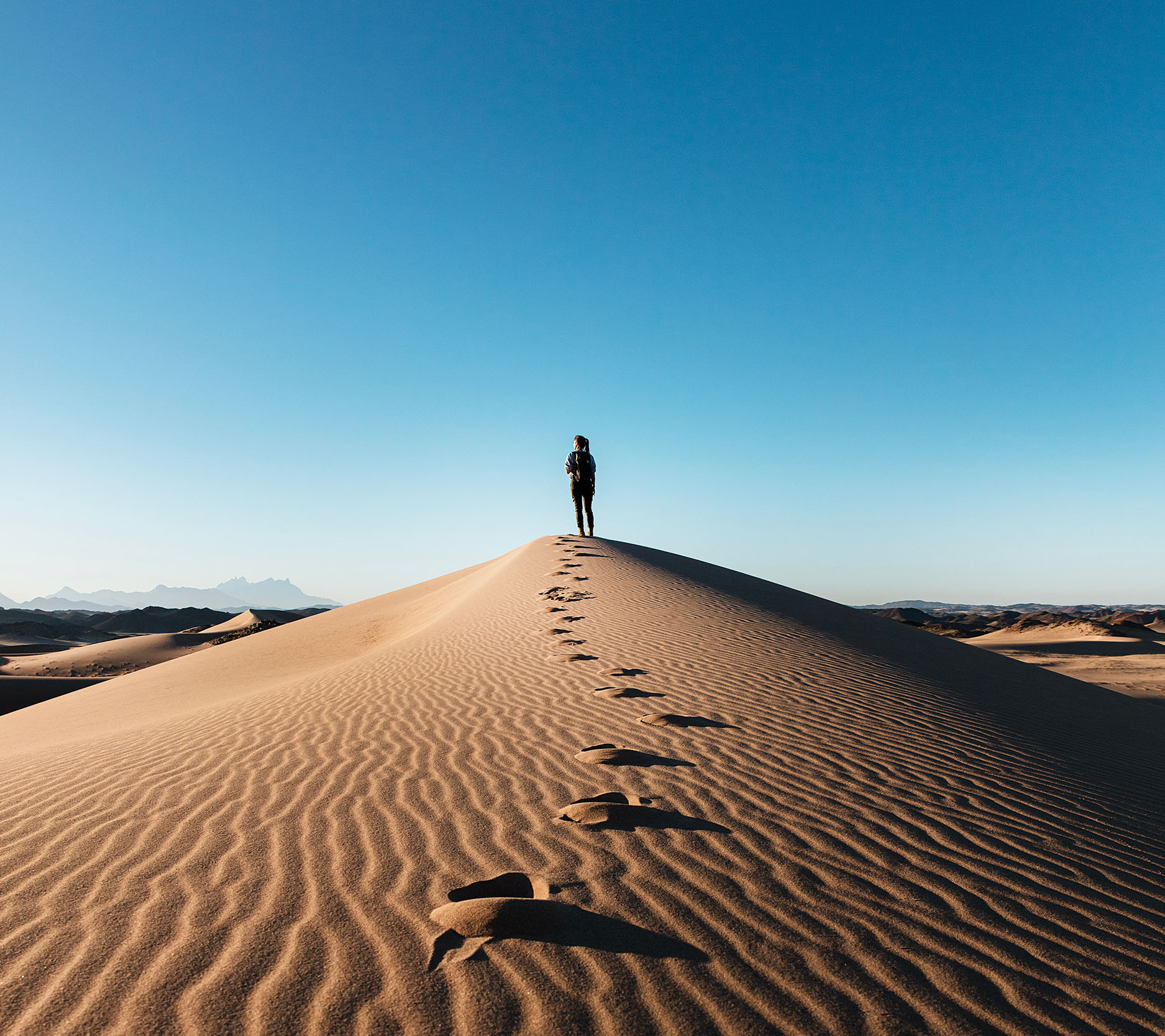 Sheaff Brock in the news, Dave Gilreath publications for Medical Economics, far-off shot of a person standing on a sand dune with a trail of footprints in the sand