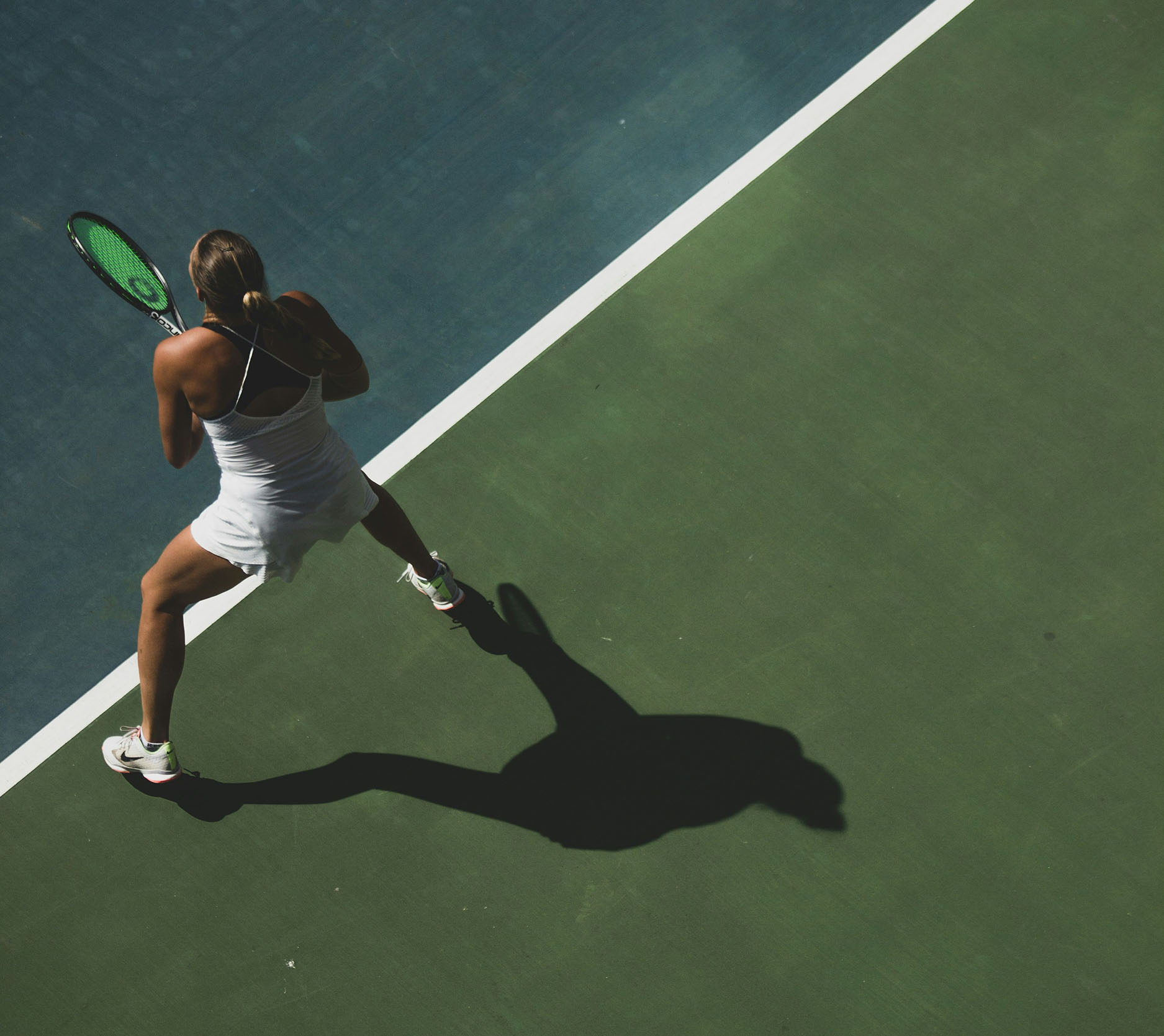 Sheaff Brock market update newsletters, June 2024, overhead shot of woman standing on tennis court with shadow behind her