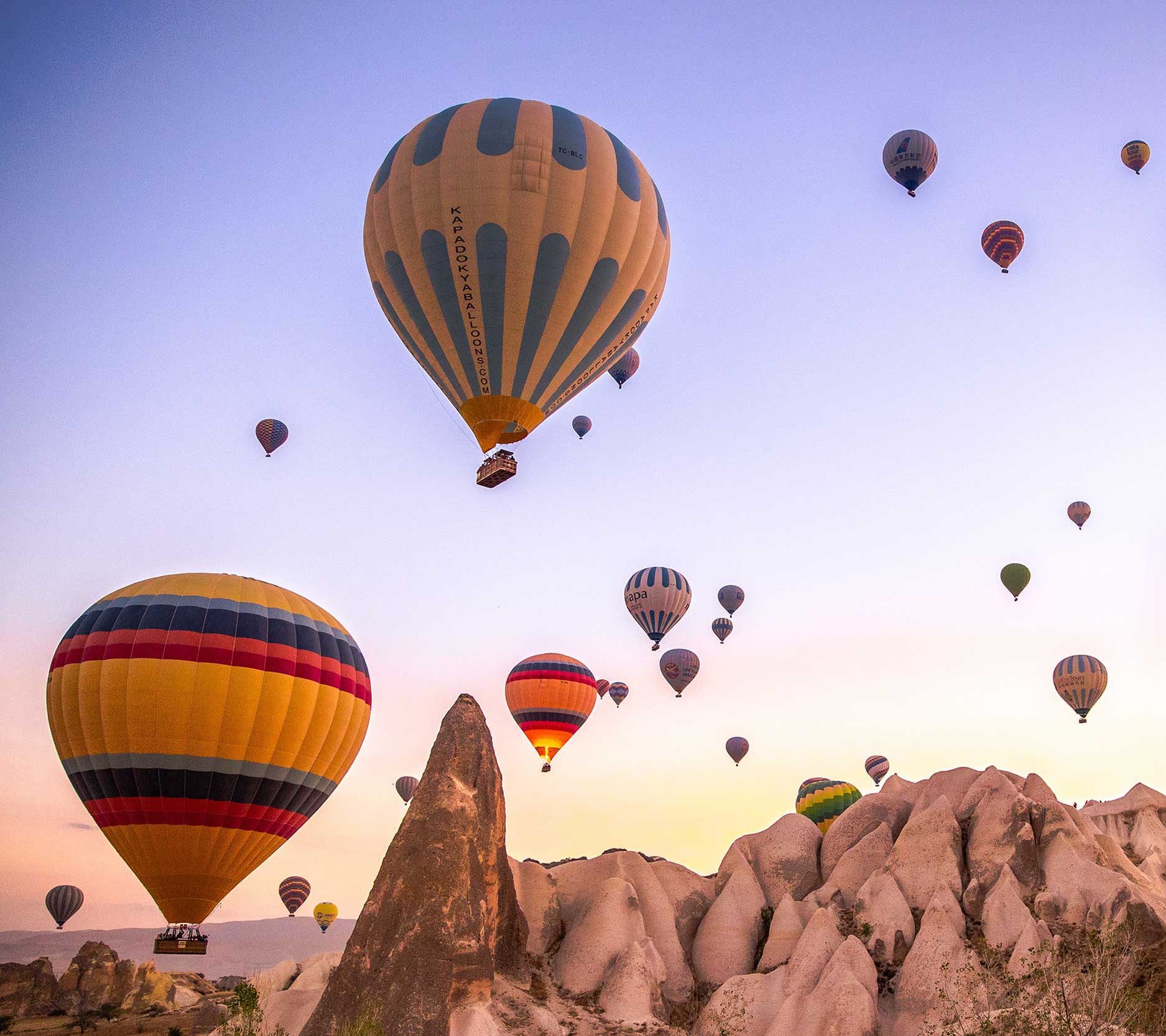 Sheaff Brock market update newsletters, December 2024, a group of hot air balloons rising around sunset above rock formations